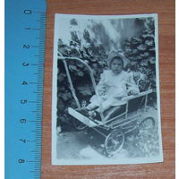 Старое фото ребенка в коляске.